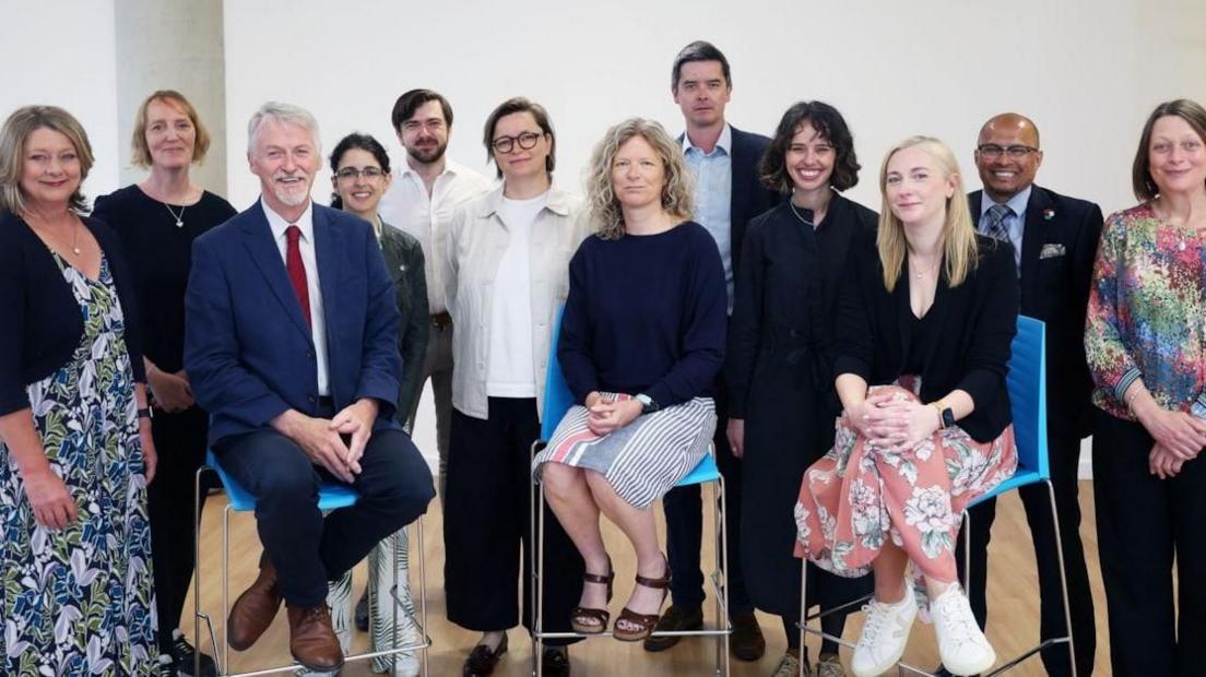Mae'r grŵp yn cael ei gadeirio gan Anwen Elias (sy'n eistedd yn y canol)