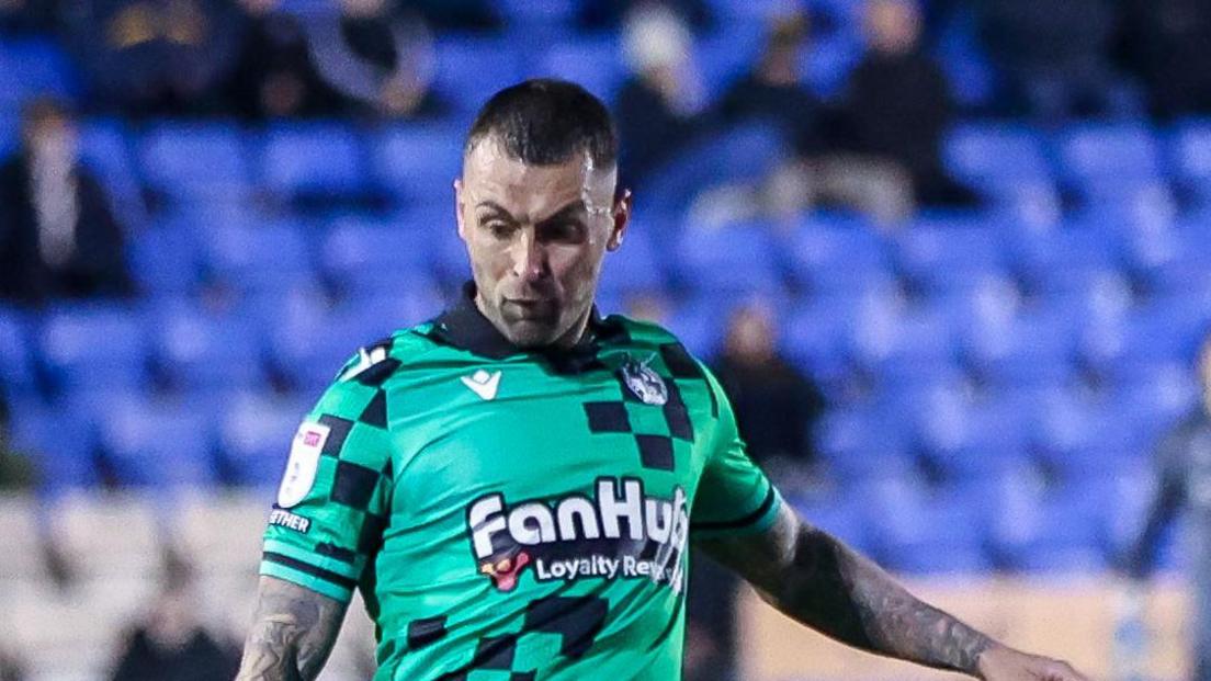 Jack Hunt playing for Bristol Rovers in a green away kit