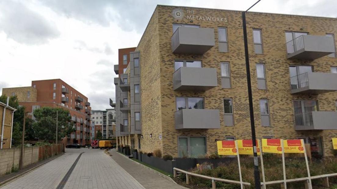 Apartment blocks - including Ironhouse - on an estate. Some are of red brick others have sand-coloured bricks. Some of the apartments have grey, metal balconies.