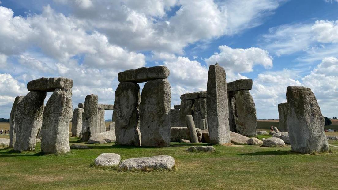 Stonehenge in the sun. It is a collection of large stones places in a circle.