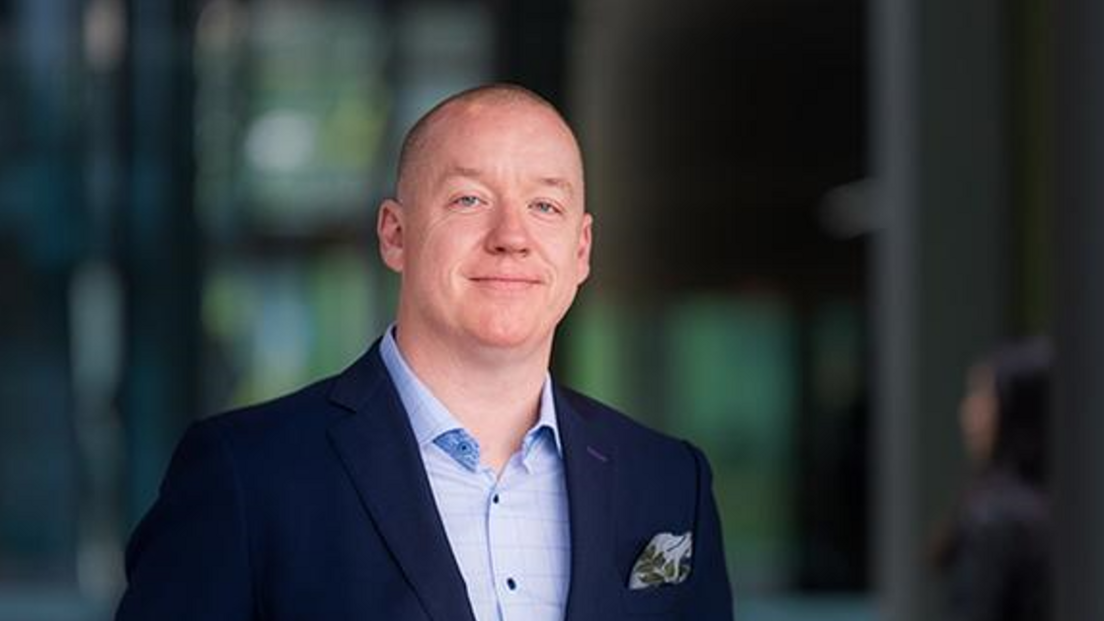 Professor Ken Sloan wearing a navy suit and blue shirt