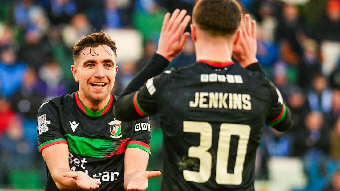 Joe Thomson celebrates Glentoran's winning goal with Jordan Jenkins