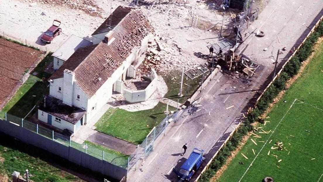 Aerial view of Loughgall police station shows part of the perimeter fence and the building destroyed by the IRA bomb while the blue van in which most of the IRA members were killed is visible and the bottom of the picture
