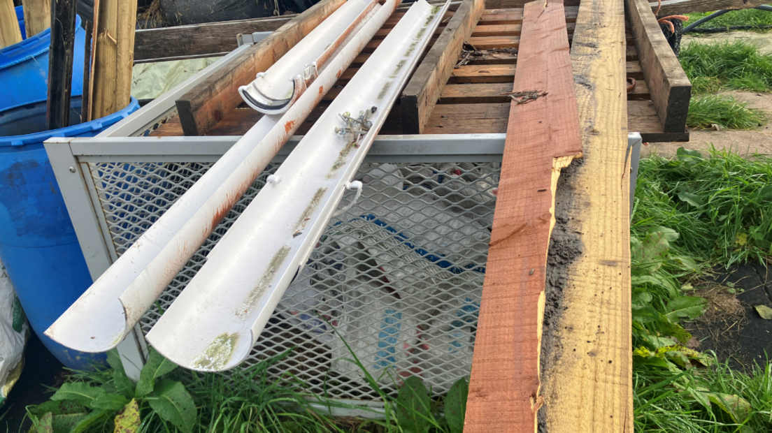White guttering and planks of broken wood are gathered on a plot of land.