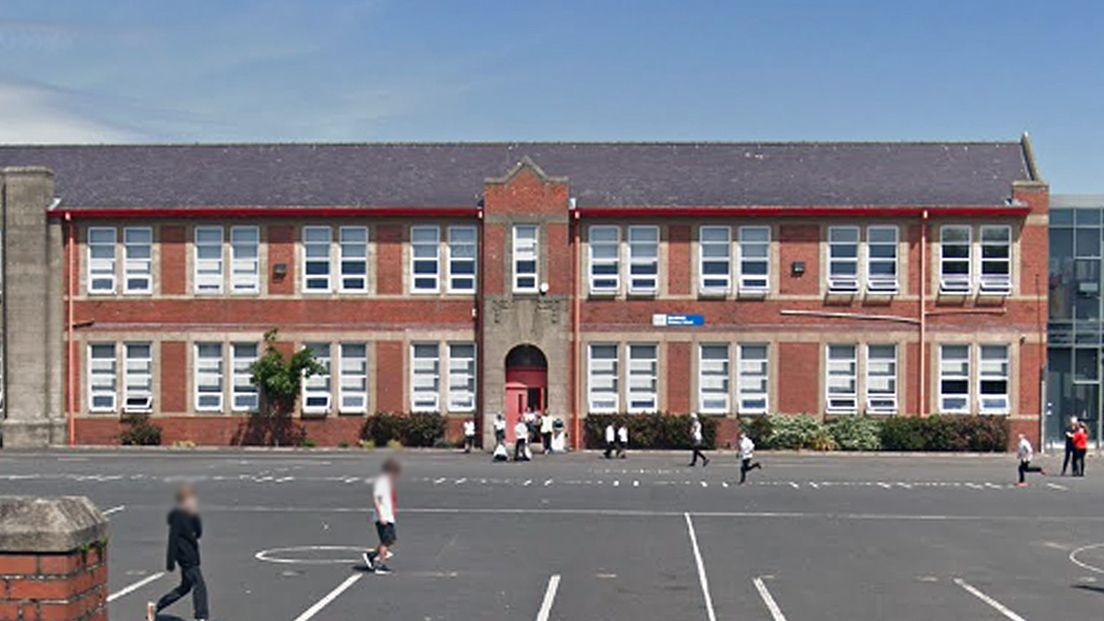 Heathfield Primary - a red brick school building with a playground in front of it