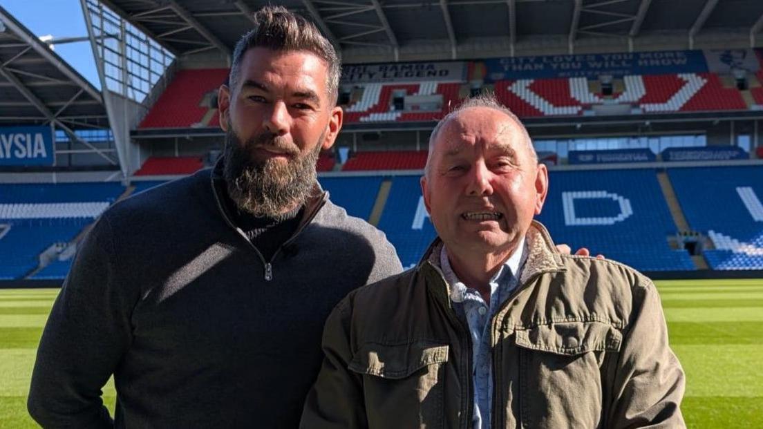 Joe Ledley a Chris Griffiths yn sefyll ar gae pêl-droed Clwb Dinas Caerdydd.