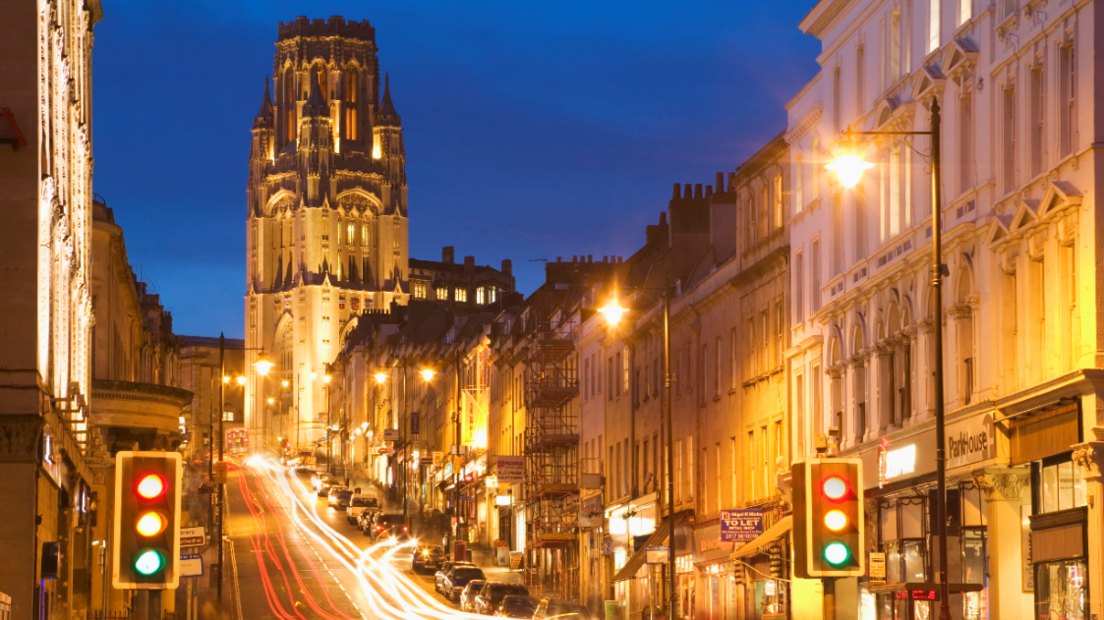 A low exposure shot of Bristol's Park Street taken from the bottom of the hill looking up at the University of Bristol. The picture and buildings are lit up by orange street lights and car headlights.