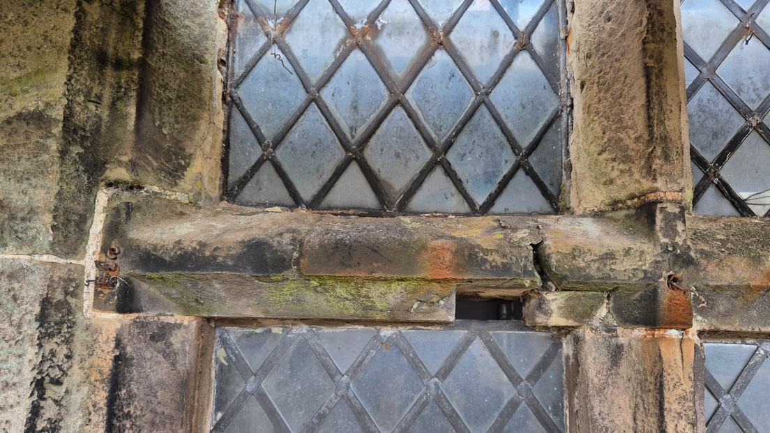 Gaps in stonework on a latticed window