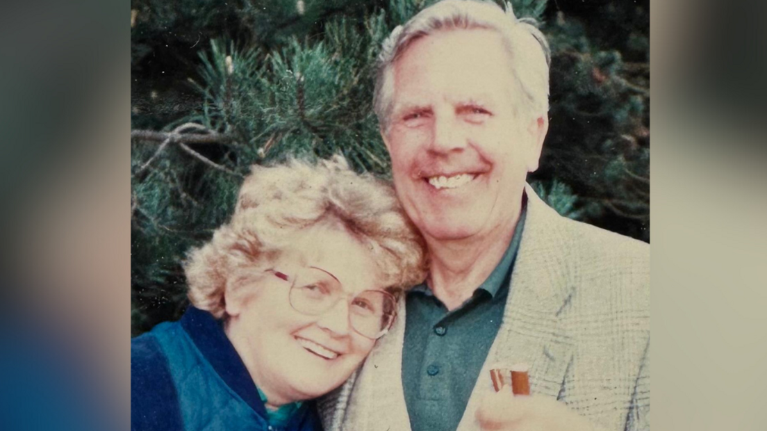 On the left is Peggy Dack who has short curly hair. She was wearing glasses and a blue top. Stood next to her on the right is Brian Dack who had short grey hair and was wearing a green polo shirt with a blazer.