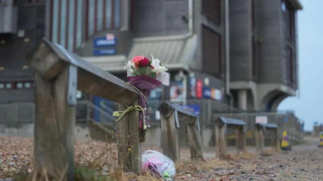 floral tributes left outside the RNLI building on the shore