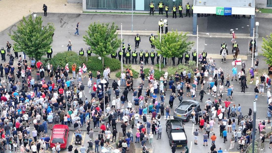 Crowds outside the Holiday Inn Express in Rotherham while it was being used as an asylum hotel