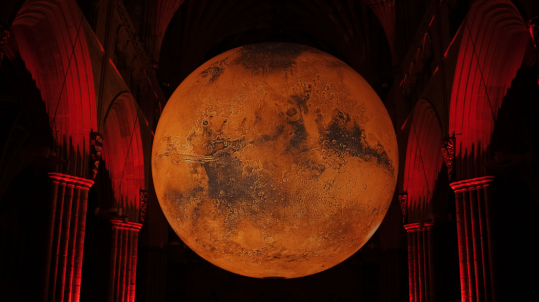 A large red coloured orb suspended between stone arches