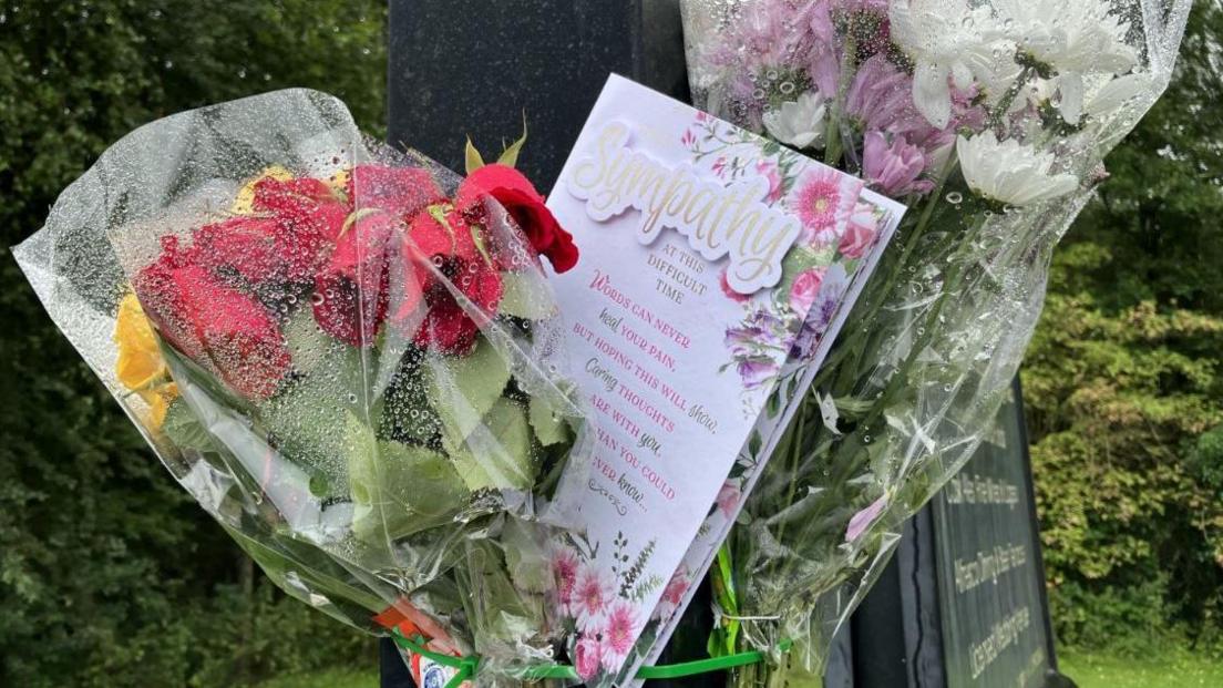 Floral tributes pinned to a lampost