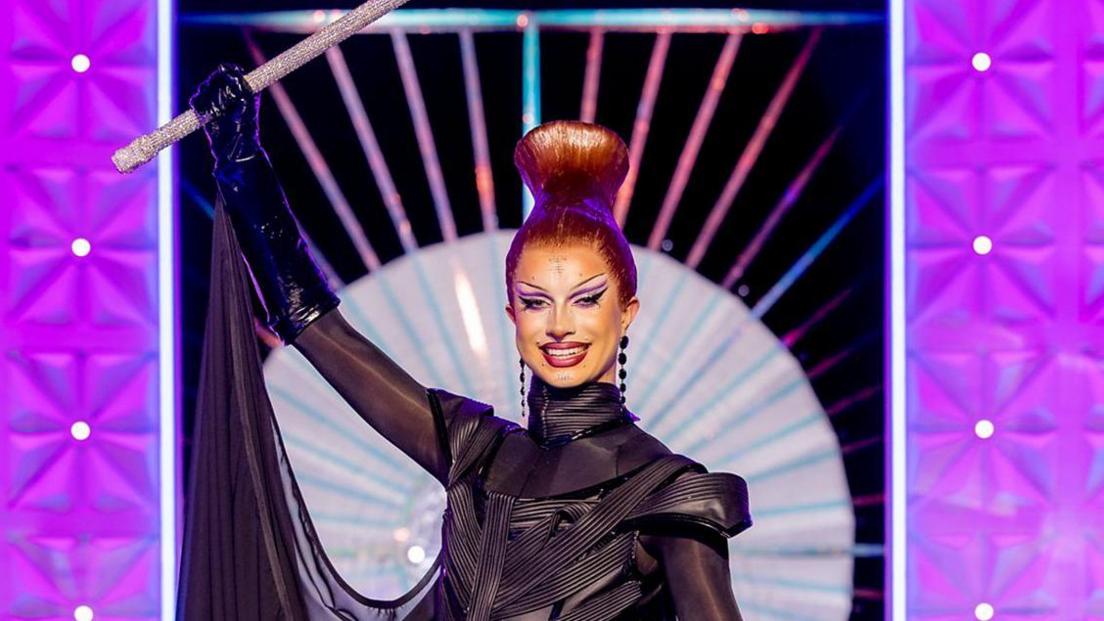 Bones wears a black gown and is holding a sceptre above her head.