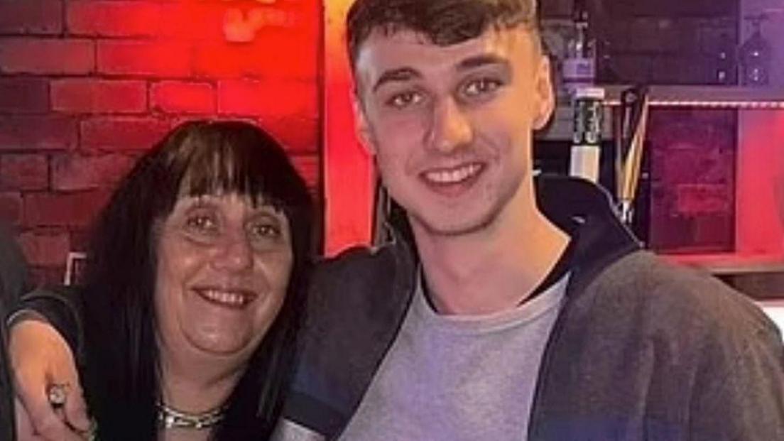 Jay Slater smiles at the camera with his arm around his mother, Debbie Duncan