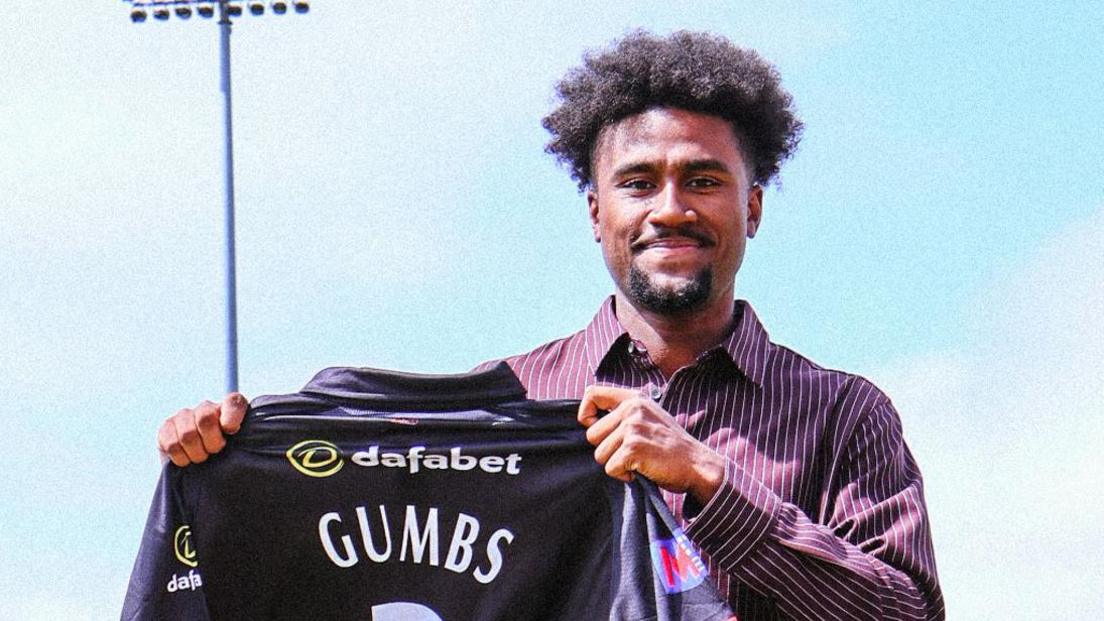 Sheridon Gumbs holds up a Leicestershire shirt after signing for the County Championship side