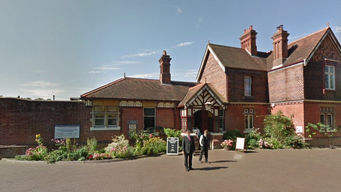 An exterior view of Sheffield Park station, which is a large brown building in the shape of a house