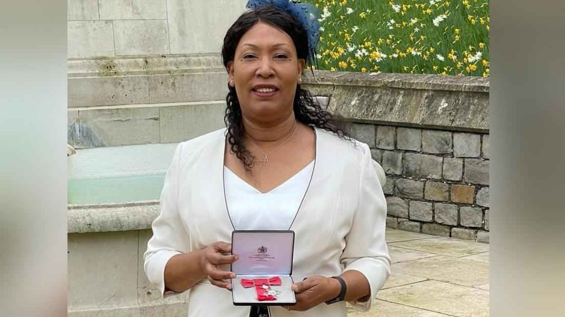 Arlene Wellman holds her MBE medal