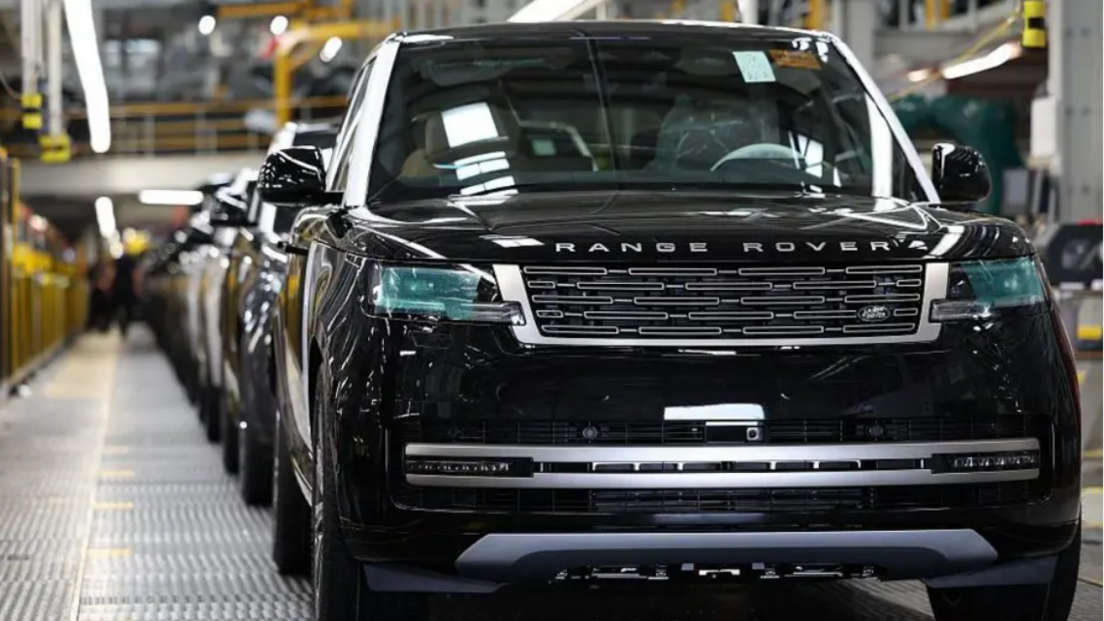 A row of black Range Rover cars on a production line