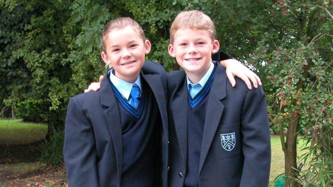 Ryan and Charlotte posing for a photo wearing their school uniform