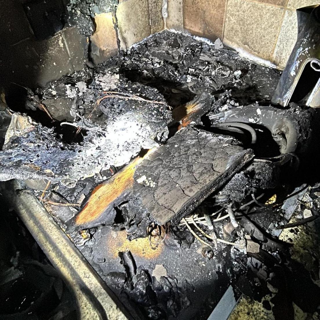 Kitchen equipment - presumably the air fryer - burnt to a blackened pile of metal and ash.