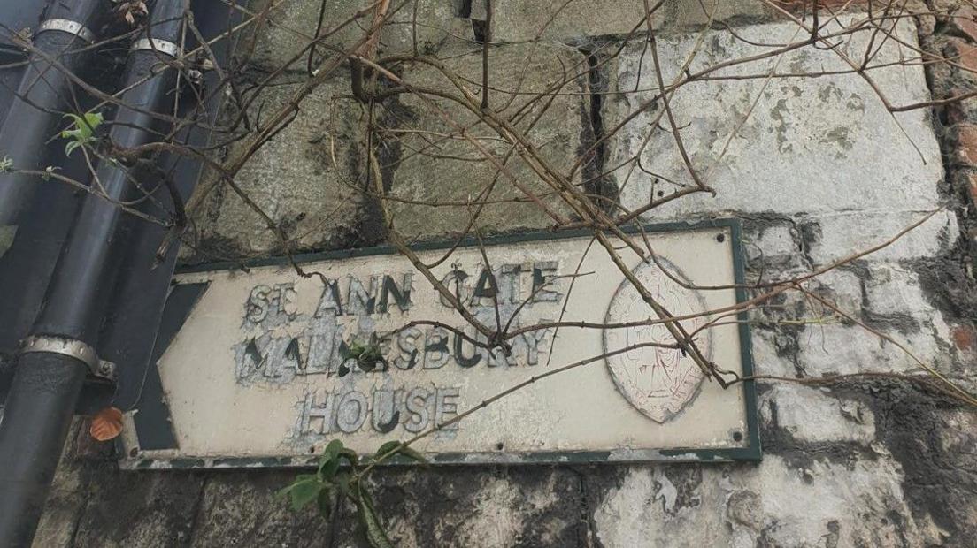 An old street sign close-up against the wall