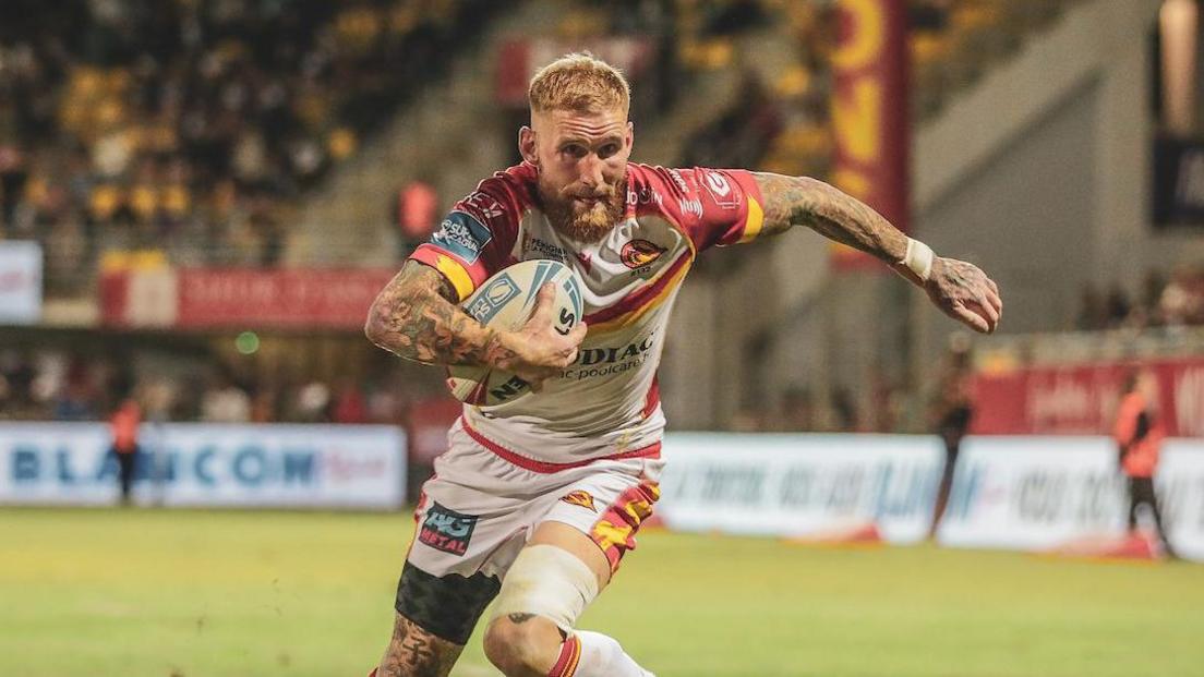 Catalans Dragons' Sam Tomkins drives with ball in hand