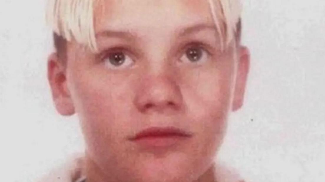 Robert Williams photographed as a boy. He has blonde hair parted to the sides and shaved shorter underneath and brown eyes.