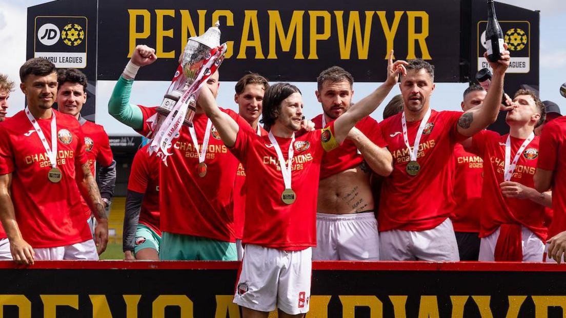Jordan Davies leads the celebrations after Trefelin BGC were crowned Cymru South champions last season