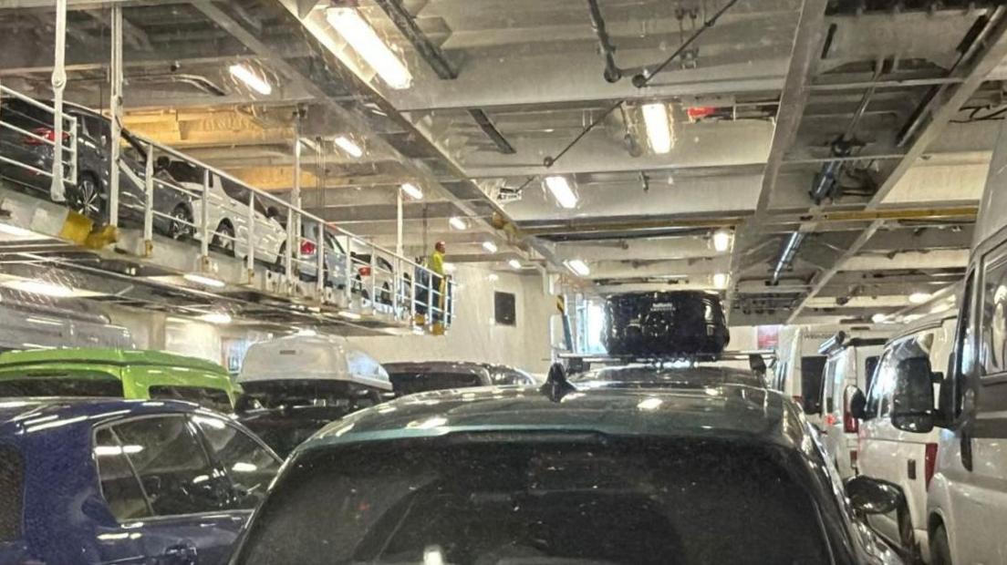 Carbadan agus luchd-siubhail glacte air deic nan càraichean aig an Loch Seaforth agus an ramp-toisich aice briste