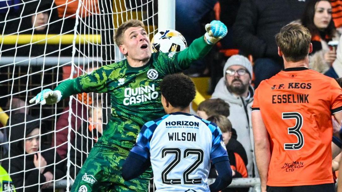 Yevhen Kuchurenko punches the ball into his own net