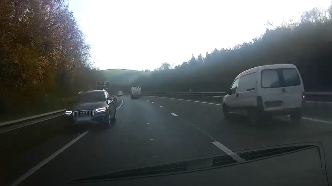 A dashcam video shows a black audi driving the wrong way down the inside of the A38 towards oncoming traffic. A white van is driving in the outside lane.