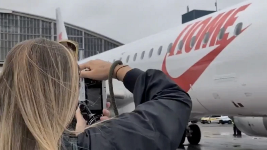 Georgia Stanway seen taking a picture of the logo on the side of the aircraft bringing home the England players.