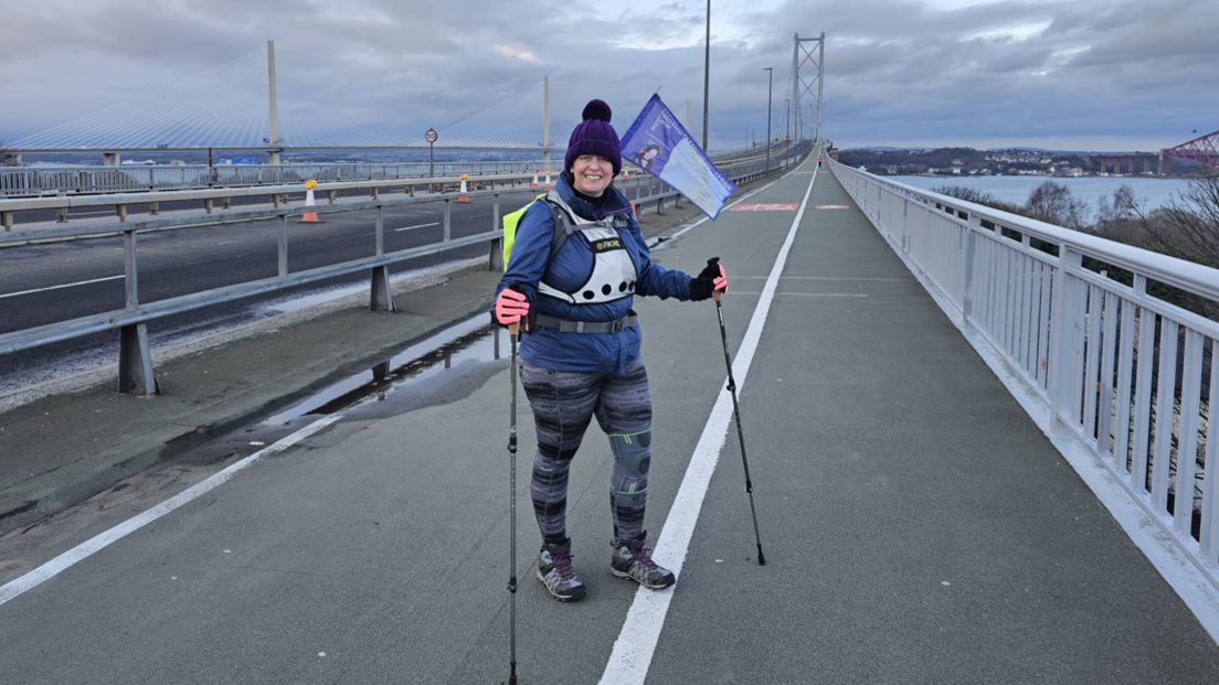 Lisa Foster walking across a bridge