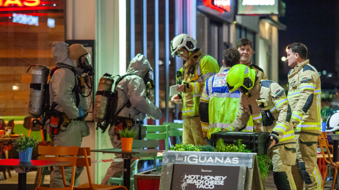 A group of firefighters in protective clothing outside Las Iguanas restaurant in Cardiff Bay in the dark