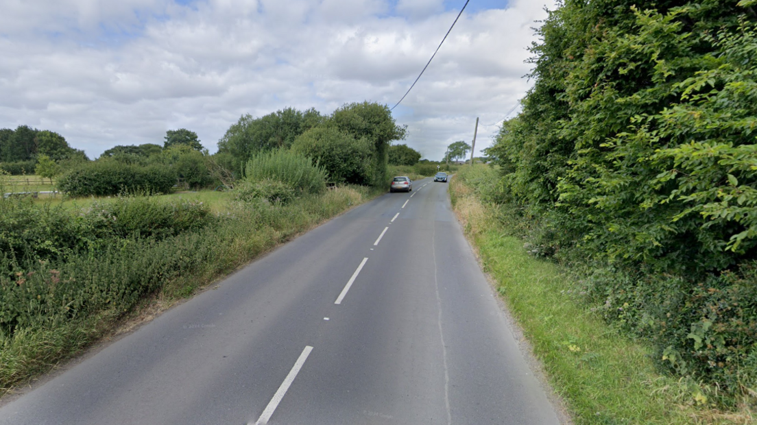 Rural tree-lined 40mph road in Worton, Wiltshire