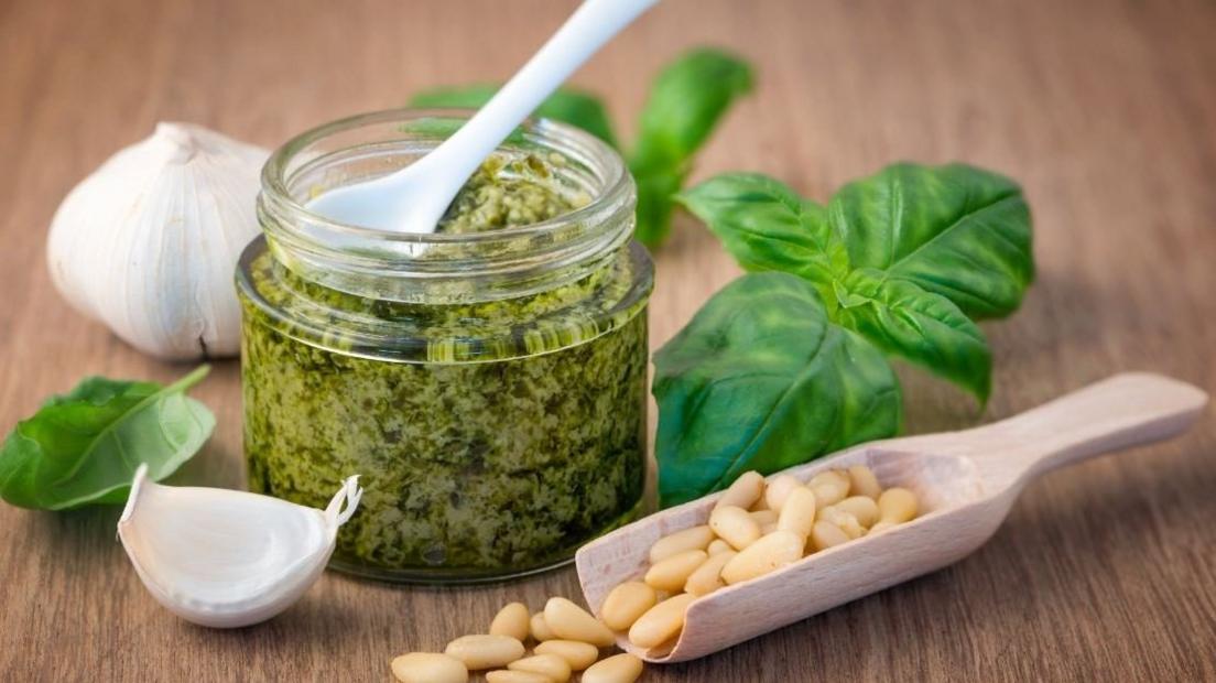 A jar of pesto with basil, pine nuts and garlic