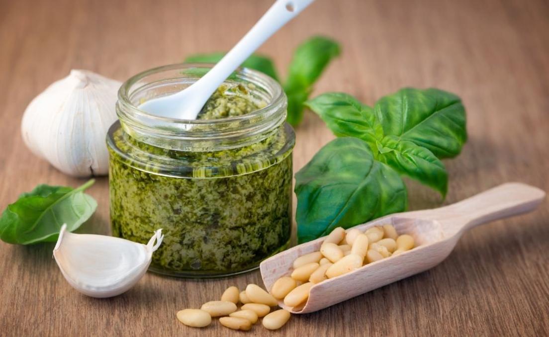 A jar of pesto with basil, pine nuts and garlic