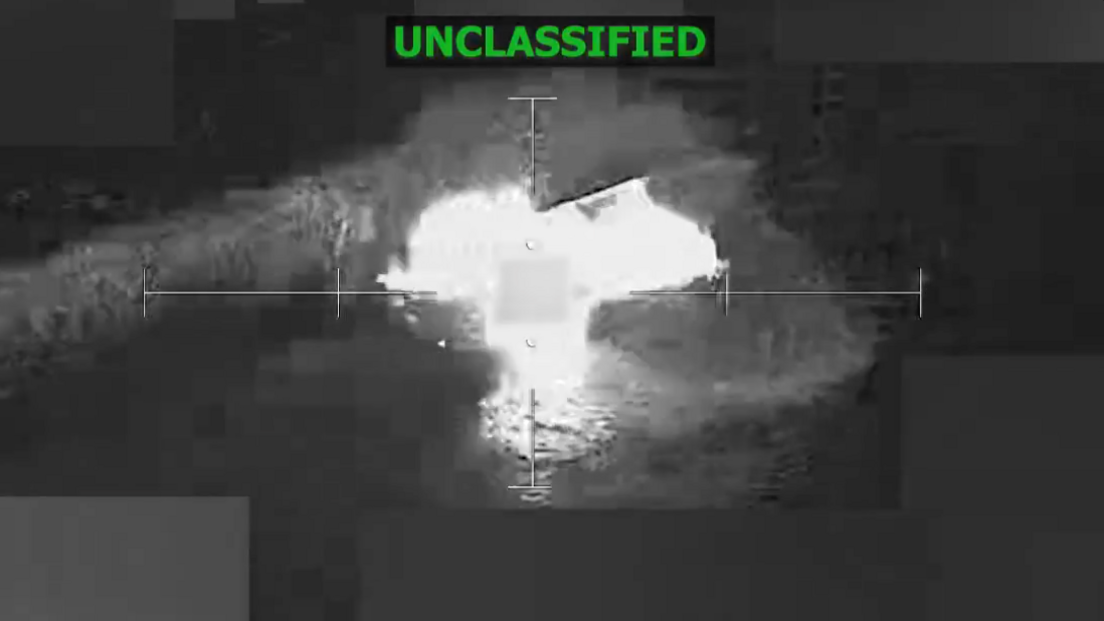Still back-and-white image from a video showing a boat exploding into a fireball in the ocean with the word "unclassified" at the top