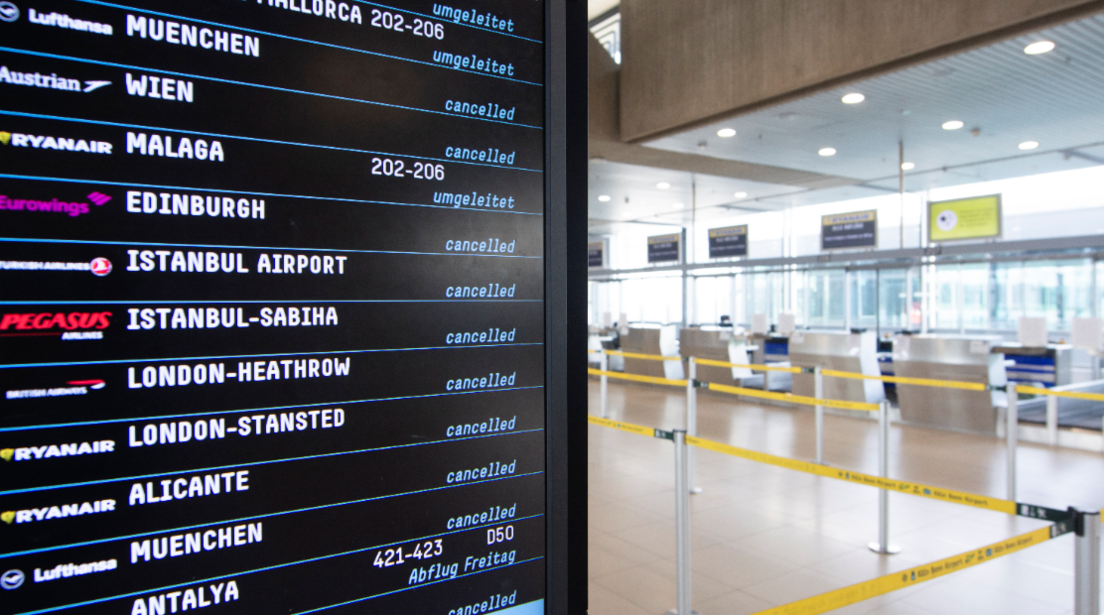 Departure boards at Cologne Airport showing cancellations and disruptions