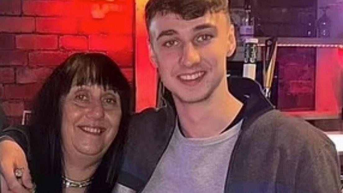 Jay Slater smiles into the camera with his arm around the shoulders of his mother, Debbie Duncan