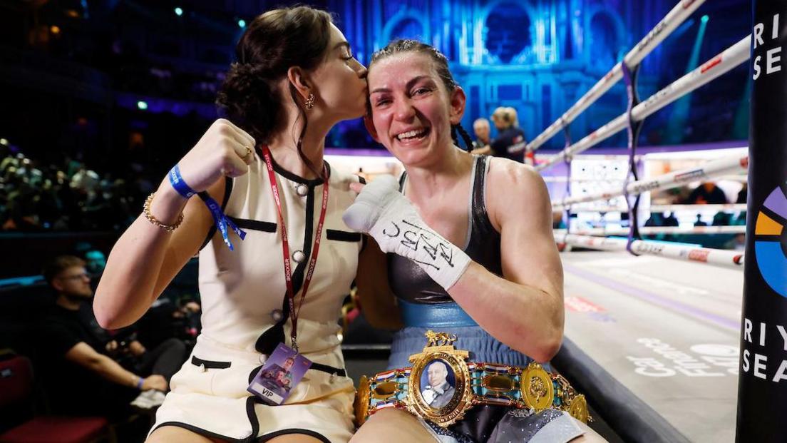 Georgia O'Connor kisses Karriss Artingstall on the forehead at ringside