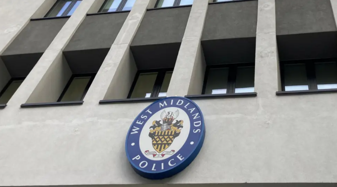 A blue West Midlands Police logo on the front of a grey wall