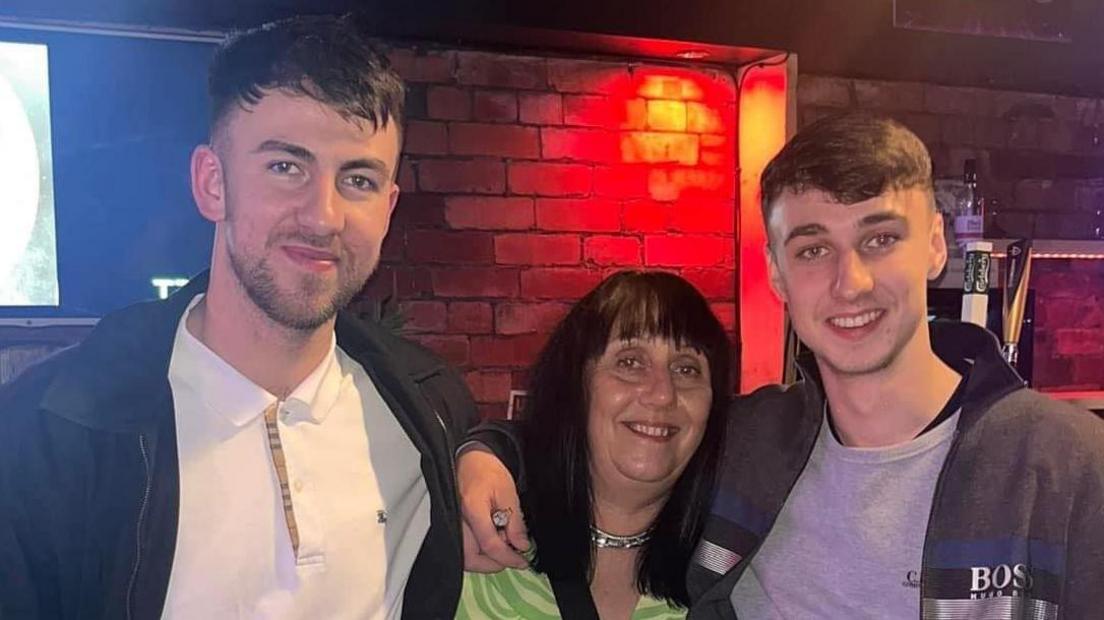 Group picture of brother Zak Slater, mother Debbie Duncan and Jay Slater smiling in a bar