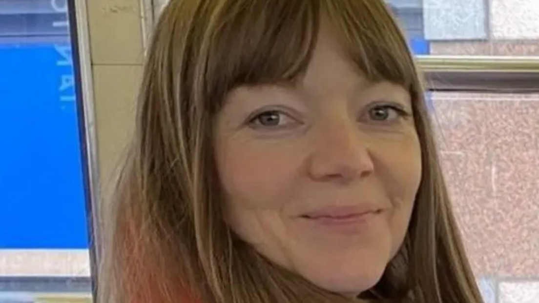 Joanne Samak, a woman with long light brown hair, smiles at the camera.