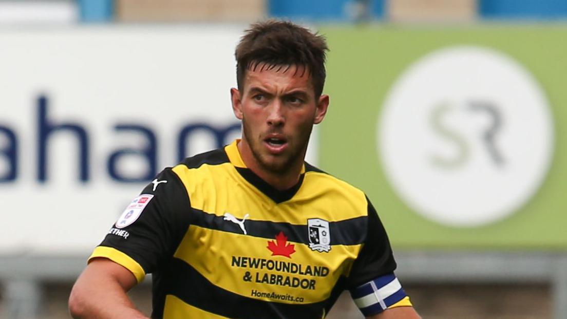 Niall Canavan, wearing Barrow's away kit, playing against Carlisle in August 2024  