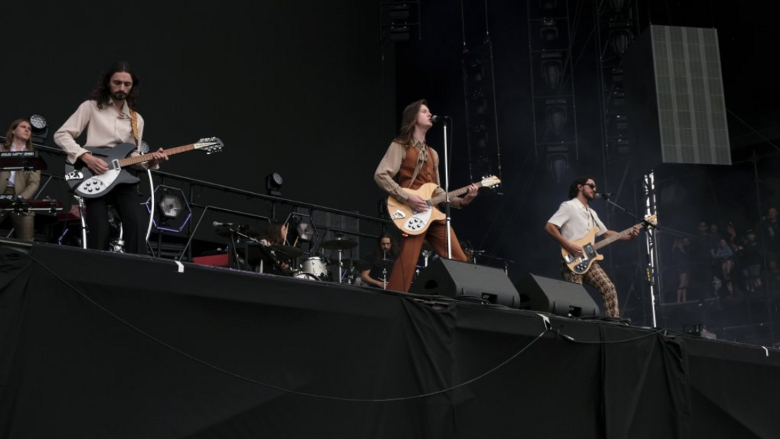 The Blossoms on stage, with the lead singer Tom Ogden playing guitar alongside two of his bandmates