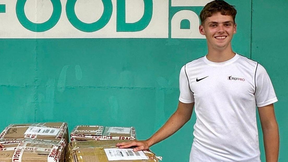 Alfie Watts with boxes of football kit