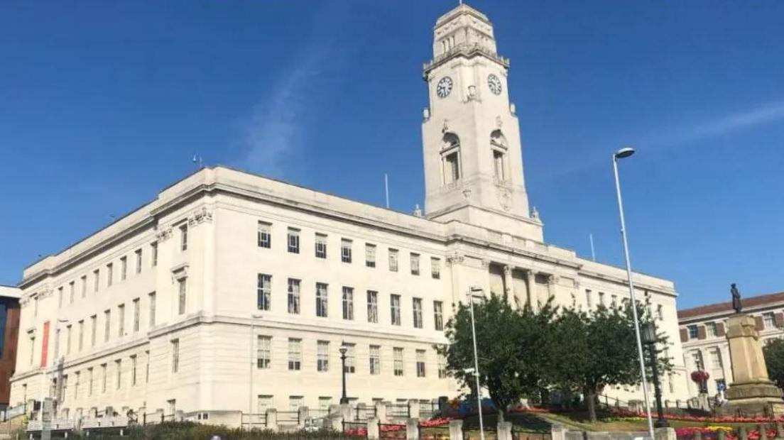 Barnsley Council building - a large white building with a clock tower, trees and statue in front.