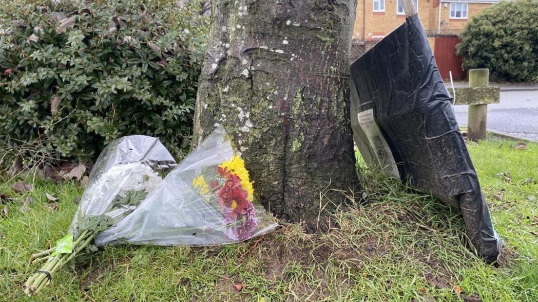 Fresh flowers in Babbs Mill at what has become a permanent shrine to the four children